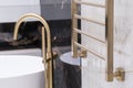 gold-colored heating radiator on a granite wall in the bathroom Royalty Free Stock Photo