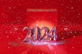 2024 gold colored numbers and glittering confetti on a vivid bright red background