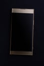 Gold colored smartphone with blank screen closeup flat on black background, top view Royalty Free Stock Photo