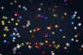 Gold colorful confetti of large size on black background. Festive backdrop of sparkles for birthday, carnival Royalty Free Stock Photo