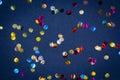 Gold colorful confetti of large size on black background. Festive backdrop of sparkles for birthday, carnival Royalty Free Stock Photo