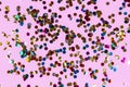 Gold colorful confetti of large size on pink background. Festive backdrop of sparkles for birthday, carnival Royalty Free Stock Photo