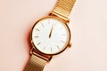 Gold coloured feminine wrist watch on a pink background. Just before 12 o clock. New year concept. Royalty Free Stock Photo