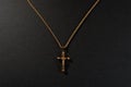 Gold cross on a chain on a black background Royalty Free Stock Photo