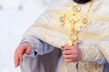 Gold cross in the hands of a priest close-up. Time to consecrate the water