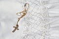 Gold cross necklace on a white first holy communion dress