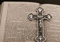 Gold cross with silver body of Jesus placed on an antique opened German Bible Royalty Free Stock Photo