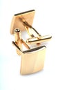 Gold cuff links on white background
