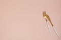 Gold cutlery. Golden spoon set, golden knife and fork on the table. Luxury spoon set top of view. Pastel punchy pink background Royalty Free Stock Photo