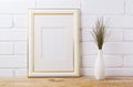 Gold decorated frame mockup with dark grass in elegant vase