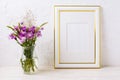Gold decorated frame mockup with purple burdocks in glass