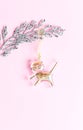 Gold decoration cat on a silver twig on a pink background. Merry christmas concept.