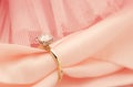 A gold and diamond ring is on a pink cloth Royalty Free Stock Photo