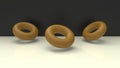 Gold donuts or rings 3d rendered object in a studio backdrop.