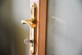 Gold door handle with key on the glass door Royalty Free Stock Photo