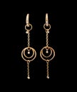 Gold earrings over black background Royalty Free Stock Photo