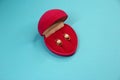 Gold earrings with pearls in red velvet box in the form of a heart on a blue background Royalty Free Stock Photo