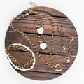 Gold earrings. Women's jewelry. Beautiful golden tones bracelet, necklaces and earrings on a wooden tray.