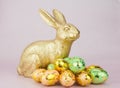 gold Easter bunny rabbit on pink background with Easter eggs Royalty Free Stock Photo