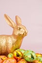 gold Easter bunny rabbit on pink background with Easter eggs Royalty Free Stock Photo