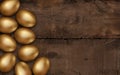 Gold Easter eggs on dark wooden background. Rustic dark background. Colorful golden easter eggs on a wooden table. Invitation