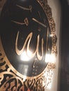 Gold embossed calligraphy bearing the name of God in Arabic "Allah"