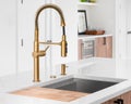 A gold faucet detail in a modern white kitchen. Royalty Free Stock Photo