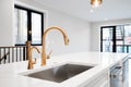 A gold faucet detail shot in a modern, luxurious kitchen.