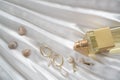 Gold female earrings with pearls, bottle of perfume on a beautiful white draped satin fabric with shells. Elements of the female