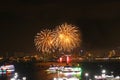 gold fireworks on beach and reflection color on water surface of light of city