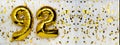Gold foil balloon number, digit ninety-two. Birthday greeting card with inscription 92. Anniversary celebration. Banner