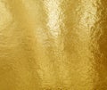 Gold foil texture background with highlights and uneven surface Royalty Free Stock Photo