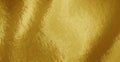 Gold foil texture background with highlights and uneven surface Royalty Free Stock Photo