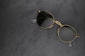 Gold frame round black sunglasses on black slate background Royalty Free Stock Photo