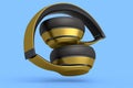 Gold gaming headphones and concept of music equipment isolated on blue.