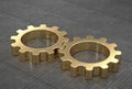 Gold gears, connected, on reflective metal tiled floor.