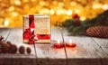 Gold gift box and pine branch with cones with candles on wooden table. Background bokeh yellow lights. Royalty Free Stock Photo