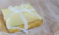 Gold gift box with white ribbon on the brown sack Royalty Free Stock Photo