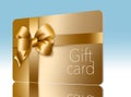 A gold gift card with a gold bow and ribbon is pictured here isolated on the background Royalty Free Stock Photo