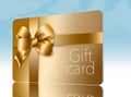 A gold gift card with a gold bow and ribbon is pictured here isolated on the background Royalty Free Stock Photo