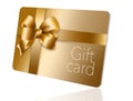 A gold gift card with a gold bow and ribbon is pictured here isolated on the background Royalty Free Stock Photo