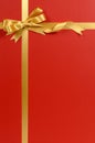 Gold gift ribbon bow, red gift wrap background, copy space, vertical Royalty Free Stock Photo