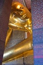 The gold gilded Reclining Buddha at Wat Pho has a serene gaze, and represents the Buddha\'s entry into Nirvana