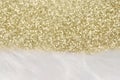 Gold glitter bokeh background with white faux fur border. Christmas backdrop with copy space