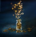 Gold glitter confetti in the small glass bottle. Close up on classik blue  background Royalty Free Stock Photo