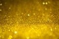 Gold glitter lights. Shiny sparkles, bokeh effects, glowing surface. Selective focus, christmas abstract background Royalty Free Stock Photo