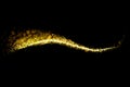 Gold glitter particles lights trail and bokeh on a black background. Abstract line sparkle texture Royalty Free Stock Photo