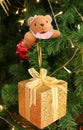 Gold Glitter Square Mini Gift Box with a Cute Squirrel Soft Toy on a Christmas Tree Royalty Free Stock Photo