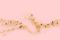 Gold glitter texture on a pink background. Abstract golden colored particles, flow of wavy shiny confetti. Festive Royalty Free Stock Photo