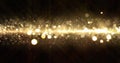 Gold glitter wave, light particles shine bokeh effect on black background. Shining gold sparks and glittering sparkling light glow Royalty Free Stock Photo